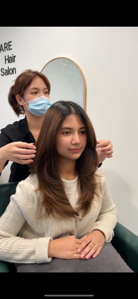 บริการตัดผมนอกสถานที่ ช่างตัดผมกำลังจัดแต่งทรงผมให้กับลูกค้าสาวสวยที่ร้านตัดผม หญิงสาวมีผมยาวสวยและมีการตัดผมแบบ layering. ช่างทำผม ตกแต่งทรงผม ทำสีผม ตัดผมสไลด์ ตัดผมผู้หญิง ทรงผมสวยๆ