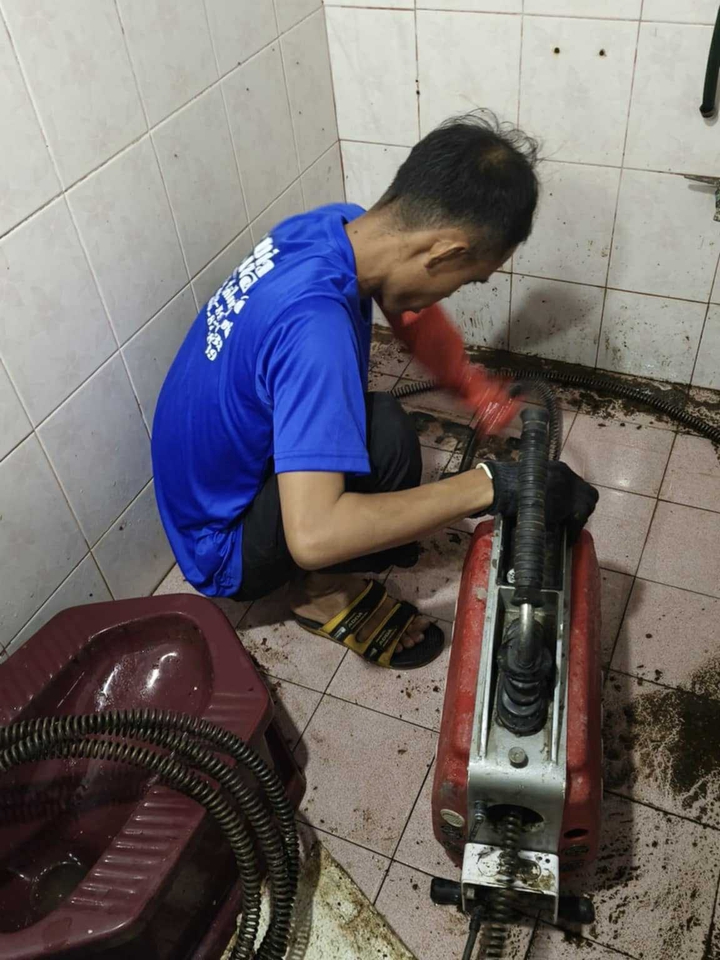 ช่างประปาซ่อมท่อระบายน้ำอุดตันด้วยเครื่องมือมืออาชีพ