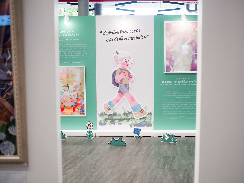 ทำ PR ประชาสัมพันธ์บริษัท: ภาพนิทรรศการที่น่าสนใจสำหรับงาน PR และการโปรโมทธุรกิจ มีตัวการ์ตูนเดิน และข้อความภาษาไทยเกี่ยวกับการรักตัวเอง พร้อมคำว่า “Chapters” เหมาะสำหรับงานประชาสัมพันธ์อย่างมาก โปรโมทบริษัทได้ดี.