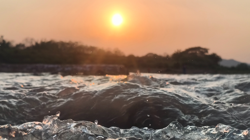 เเสงแห่งพระอาทิตย์ได้ตกกระทบกับคลื่นน้ำที่มีคลื่นกระทบกัน