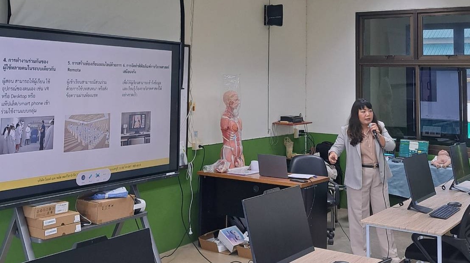 ภาพการบรรยายเรื่องธุรกิจ: วิทยากรหญิงกำลังสอนเกี่ยวกับธุรกิจผ่านหน้าจอขนาดใหญ่ในห้องเรียน