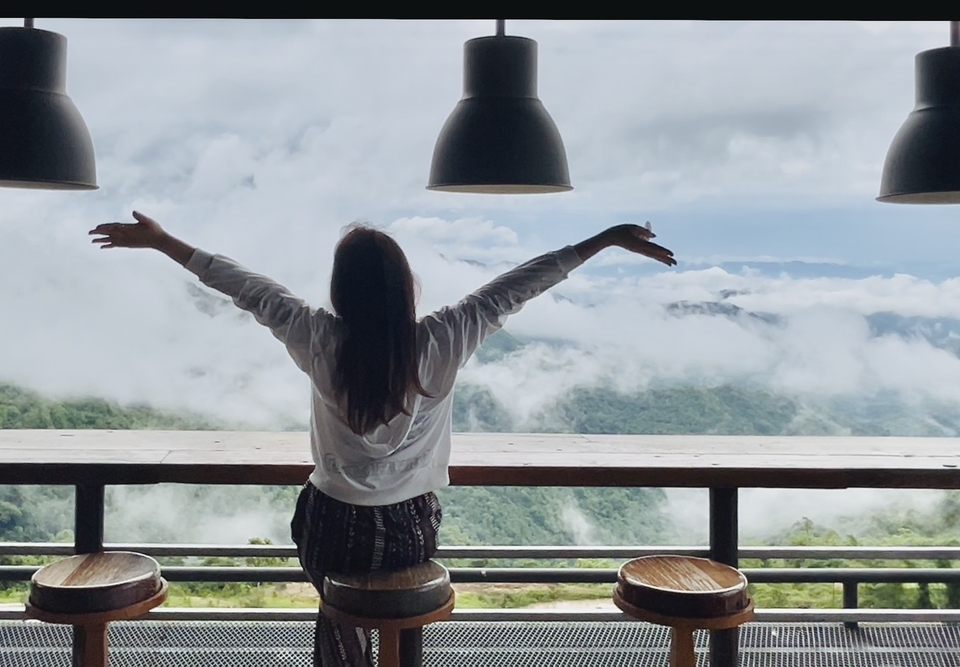 เน็ตไอดอลรีวิววิวทิวทัศน์สวยงามจากบล็อกเกอร์ท่องเที่ยวผู้หญิงที่กำลังยืดแขนสัมผัสบรรยากาศดีๆ